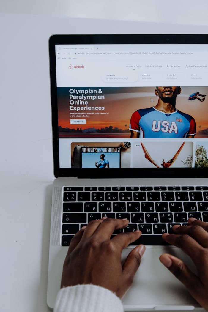 why-choose-us Hands using a laptop to browse online Olympic and Paralympic experiences.
